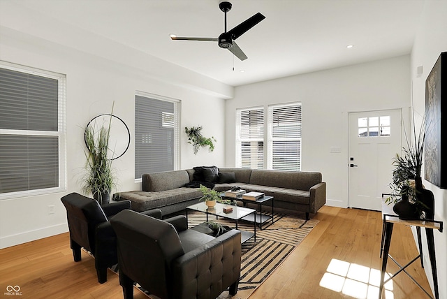 living area featuring light wood finished floors, a ceiling fan, baseboards, and recessed lighting
