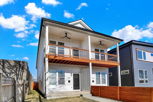back of property featuring a ceiling fan, board and batten siding, a fenced backyard, and a balcony