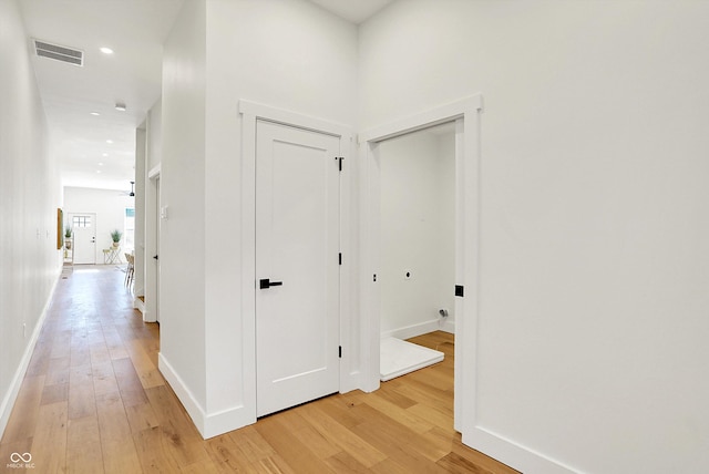 hallway with light wood-style flooring, baseboards, and recessed lighting