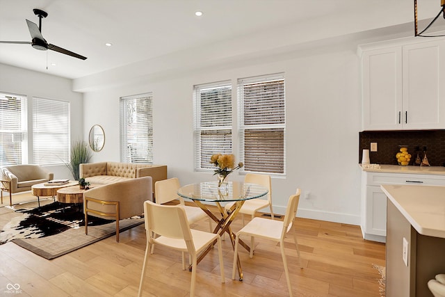 dining area featuring light wood-style flooring, a ceiling fan, recessed lighting, and baseboards