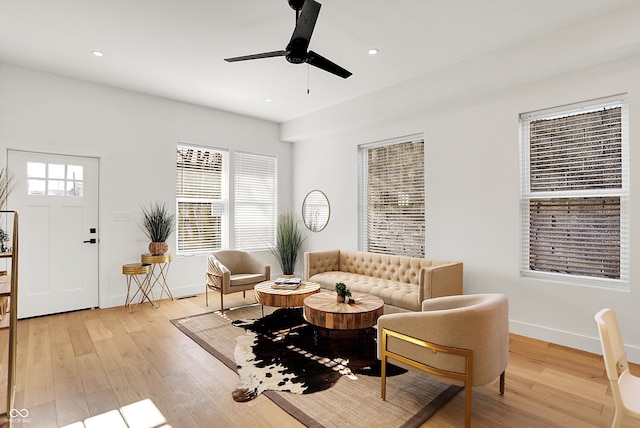 living area with light wood-type flooring, ceiling fan, baseboards, and recessed lighting