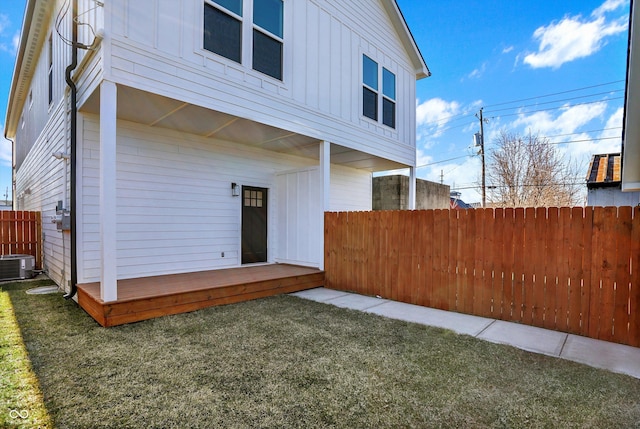 back of house featuring fence, central AC unit, and board and batten siding
