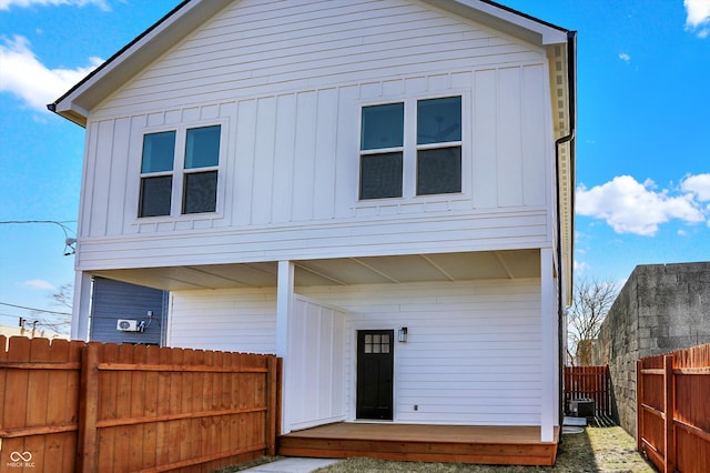 view of front of home featuring a fenced backyard, board and batten siding, and central air condition unit