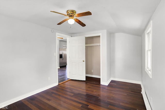 unfurnished bedroom with stainless steel fridge, baseboards, wood finished floors, a closet, and lofted ceiling