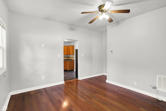 spare room featuring a ceiling fan, wood finished floors, and baseboards