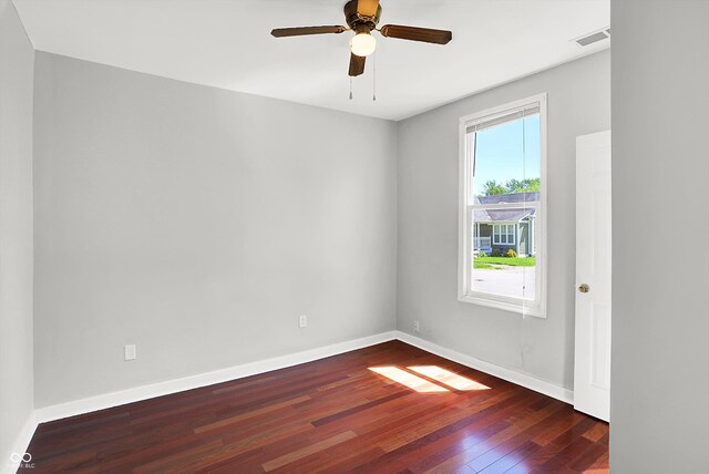 empty room with wood finished floors, baseboards, and a ceiling fan