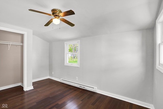 unfurnished bedroom with a baseboard radiator, vaulted ceiling, baseboards, wood finished floors, and a closet