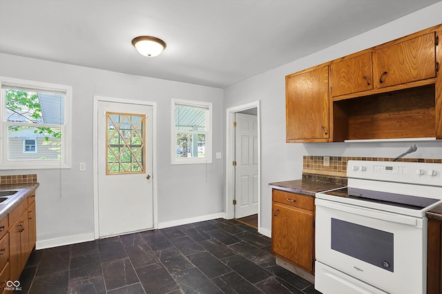 kitchen featuring white range with electric stovetop, healthy amount of natural light, and brown cabinets