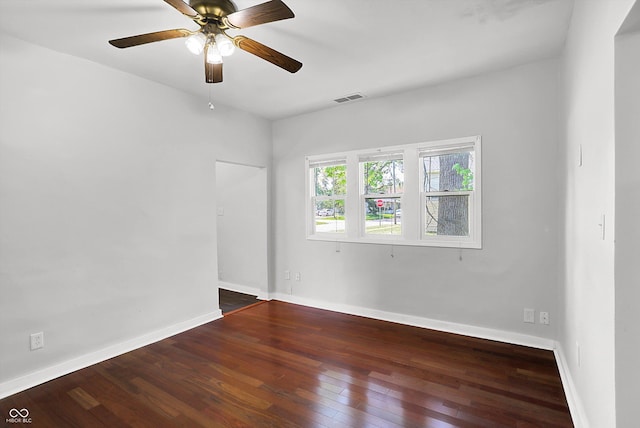 empty room with hardwood / wood-style flooring, a ceiling fan, and baseboards