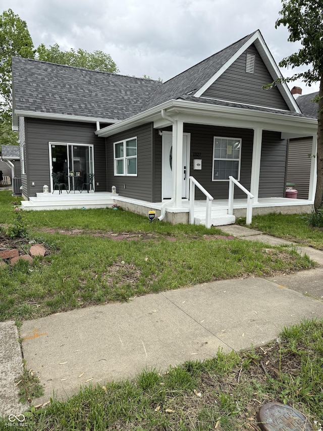 view of front facade with roof with shingles and a porch