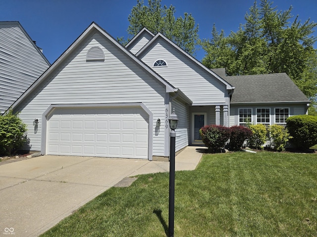 6369 Kelsey Dr, Indianapolis, IN 46268 - view of front of house featuring a front yard, concrete driveway, a garage, and a shingled roof