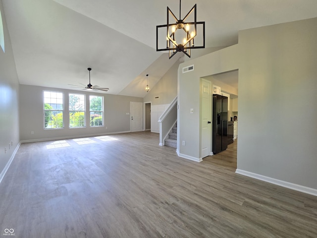 6369 Kelsey Dr, Indianapolis, IN 46268 - unfurnished living room with stairway, baseboards, lofted ceiling, a ceiling fan, and wood finished floors