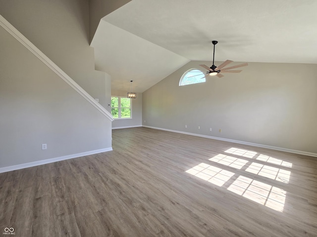 6369 Kelsey Dr, Indianapolis, IN 46268 - unfurnished living room featuring ceiling fan, vaulted ceiling, baseboards, wood finished floors, and stairway