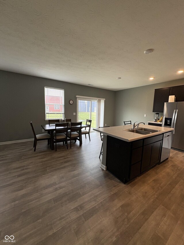 1380 Fairmount Dr, Greenfield, IN 46140 - kitchen featuring a sink, appliances with stainless steel finishes, light countertops, a center island with sink, and dark wood-style floors