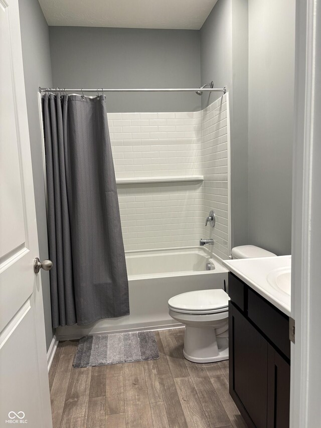 1380 Fairmount Dr, Greenfield, IN 46140 - bathroom featuring wood finished floors, toilet, shower / tub combo with curtain, and vanity