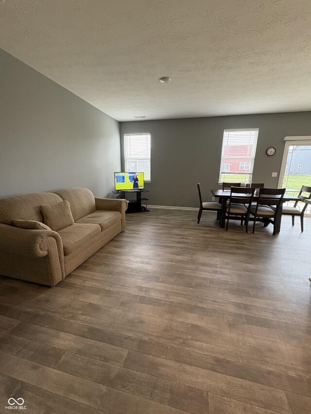1380 Fairmount Dr, Greenfield, IN 46140 - living area featuring healthy amount of natural light, dark wood finished floors, and a textured ceiling