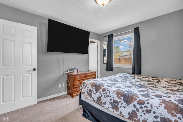 bedroom featuring light colored carpet, a textured ceiling, and baseboards