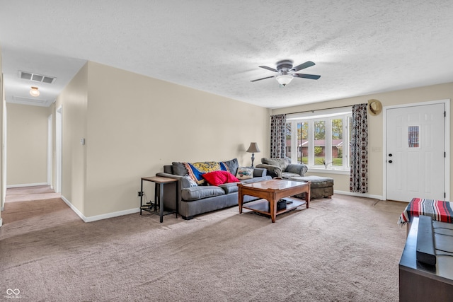 carpeted living room with a ceiling fan, baseboards, and a textured ceiling