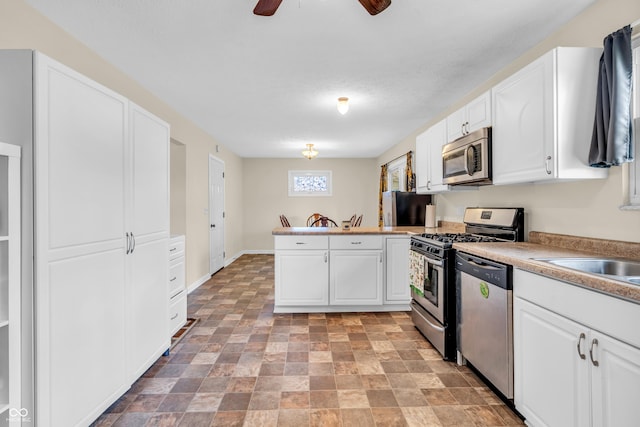 kitchen featuring appliances with stainless steel finishes, a peninsula, white cabinets, and ceiling fan