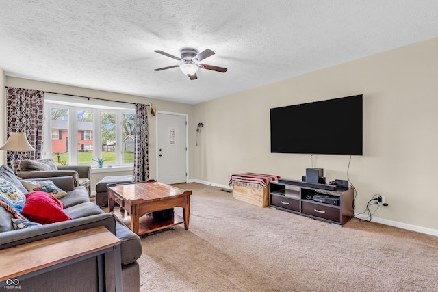 living room with ceiling fan, carpet flooring, baseboards, and a textured ceiling