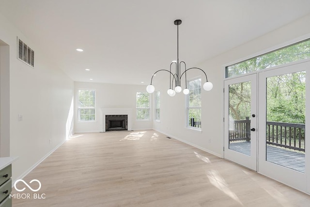 unfurnished living room with french doors, light wood finished floors, baseboards, recessed lighting, and a fireplace with flush hearth