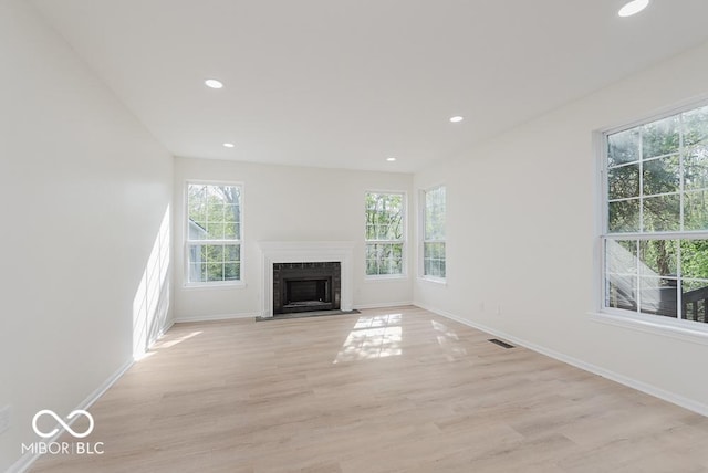 unfurnished living room featuring plenty of natural light, baseboards, light wood finished floors, and recessed lighting