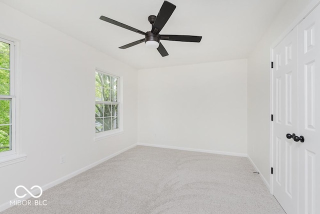 carpeted spare room with baseboards and ceiling fan
