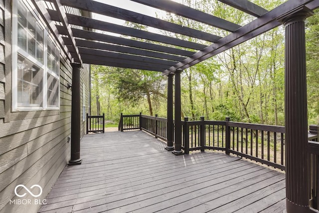 wooden terrace featuring a pergola and a view of trees