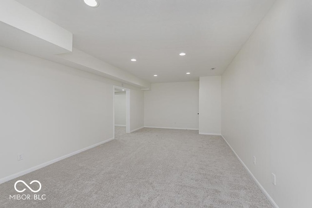 empty room featuring recessed lighting, light colored carpet, and baseboards