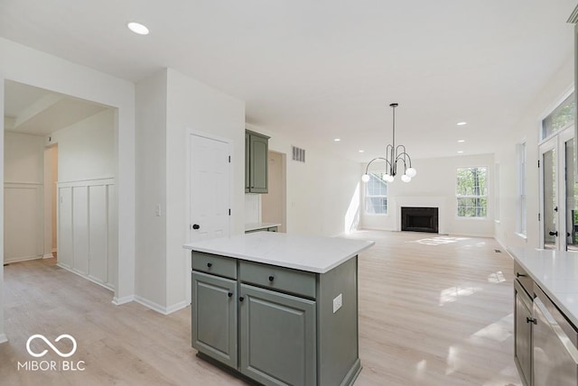 kitchen with a fireplace, light wood-type flooring, light countertops, gray cabinets, and recessed lighting