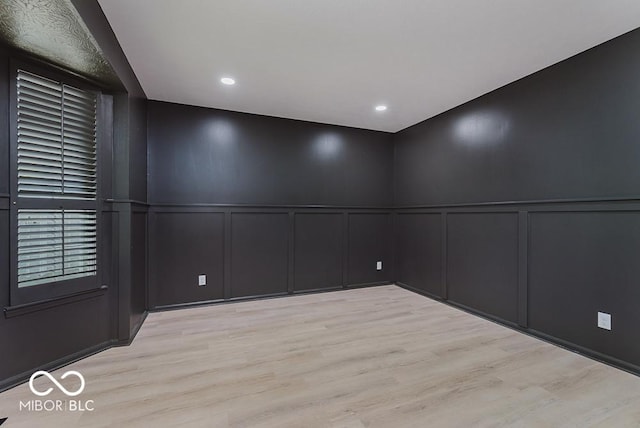 empty room with a decorative wall and light wood finished floors