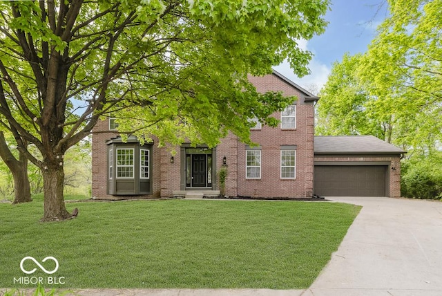 view of front of house with an attached garage, driveway, a front lawn, and brick siding