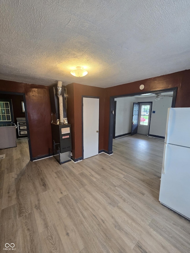 114 S Catherwood Ave, Indianapolis, IN 46219 - unfurnished living room featuring a textured ceiling, wood finished floors, and heating unit