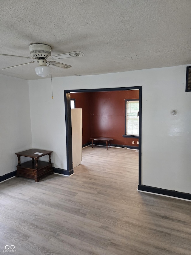 114 S Catherwood Ave, Indianapolis, IN 46219 - spare room featuring a ceiling fan, a textured ceiling, wood finished floors, and baseboards