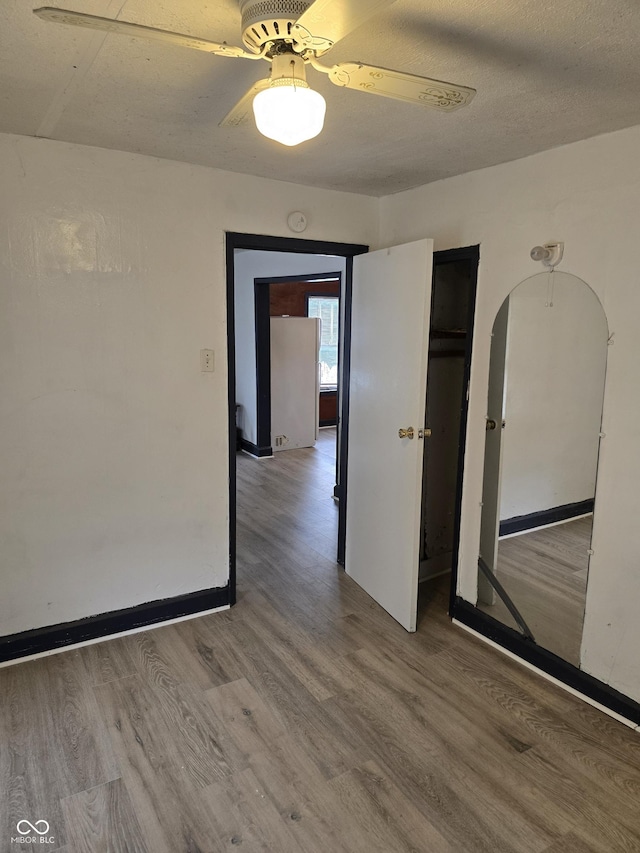 114 S Catherwood Ave, Indianapolis, IN 46219 - spare room with wood finished floors, arched walkways, a ceiling fan, baseboards, and a smoke detector