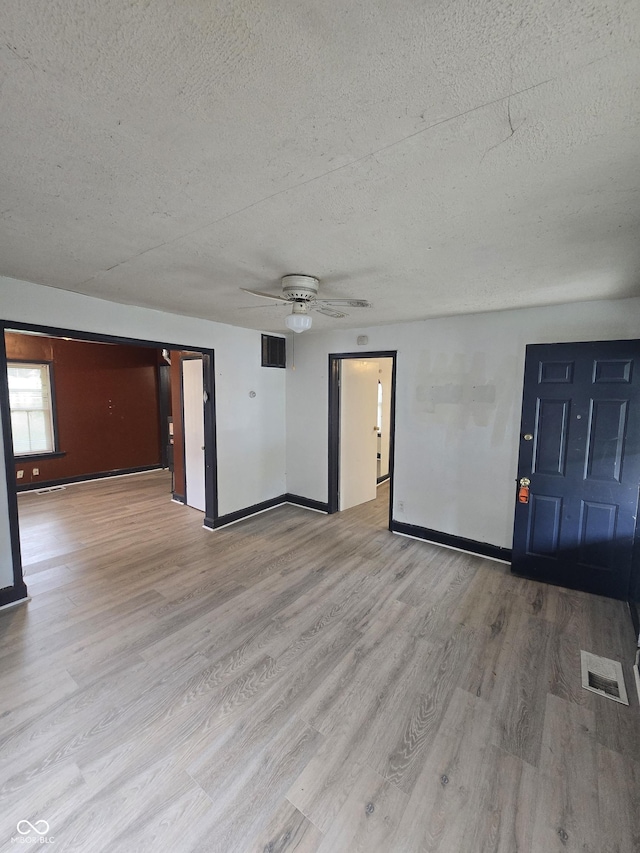 114 S Catherwood Ave, Indianapolis, IN 46219 - spare room featuring a textured ceiling, wood finished floors, baseboards, and a ceiling fan