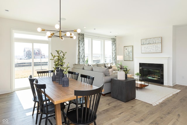 175 Rock Island Rd, Westfield, IN 46074 - dining space with light wood finished floors, a fireplace with flush hearth, and a chandelier