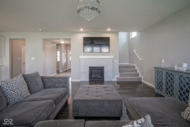 living room featuring wood finished floors, baseboards, recessed lighting, stairs, and a fireplace