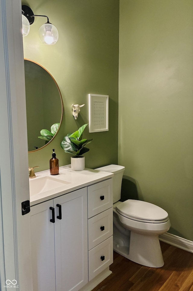 4601 Fairhope Dr, Indianapolis, IN 46237 - half bathroom featuring toilet, wood finished floors, vanity, and baseboards