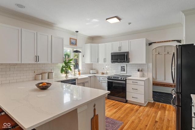 4601 Fairhope Dr, Indianapolis, IN 46237 - kitchen with stainless steel appliances, a peninsula, a sink, ornamental molding, and light wood-style flooring