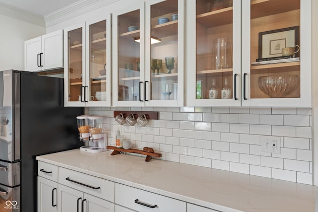 4601 Fairhope Dr, Indianapolis, IN 46237 - kitchen featuring freestanding refrigerator, ornamental molding, decorative backsplash, white cabinetry, and glass insert cabinets