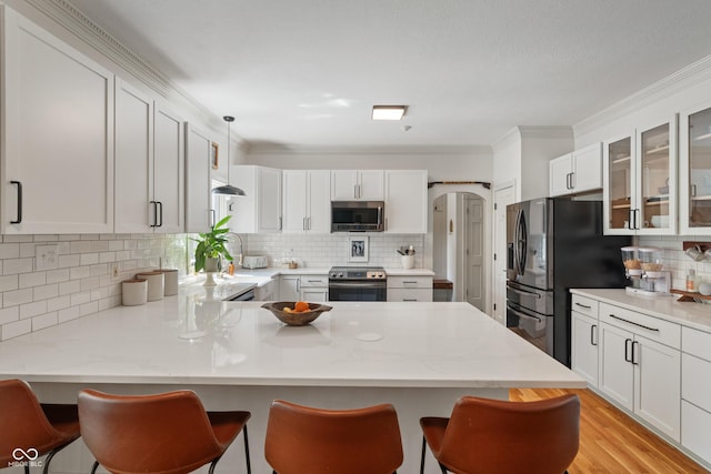 4601 Fairhope Dr, Indianapolis, IN 46237 - kitchen featuring stainless steel appliances, tasteful backsplash, a peninsula, glass insert cabinets, and crown molding