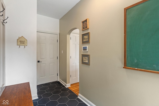 4601 Fairhope Dr, Indianapolis, IN 46237 - hallway featuring arched walkways, baseboards, and dark tile patterned floors