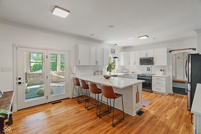 4601 Fairhope Dr, Indianapolis, IN 46237 - kitchen with stainless steel appliances, a peninsula, crown molding, a breakfast bar, and tasteful backsplash