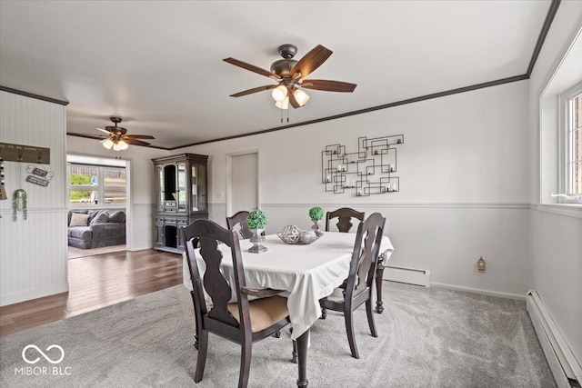 dining space featuring a baseboard radiator, ceiling fan, baseboard heating, baseboards, and wood finished floors