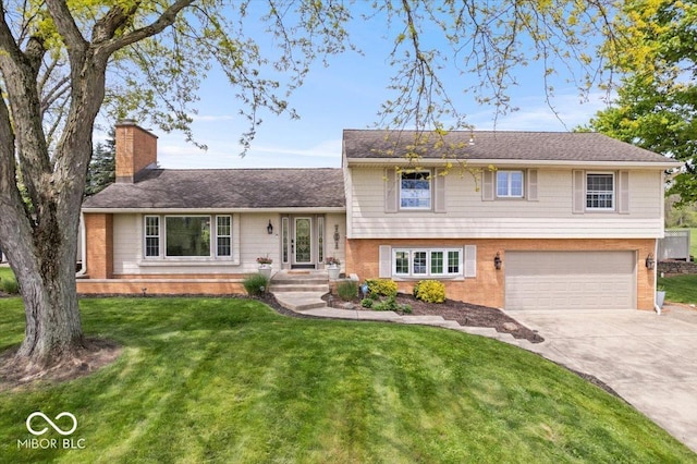 split level home featuring a chimney, driveway, an attached garage, and brick siding
