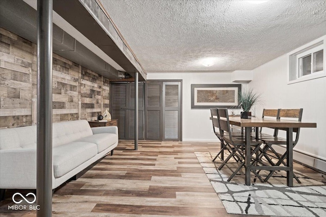 dining room with wood finished floors, baseboards, and a textured ceiling