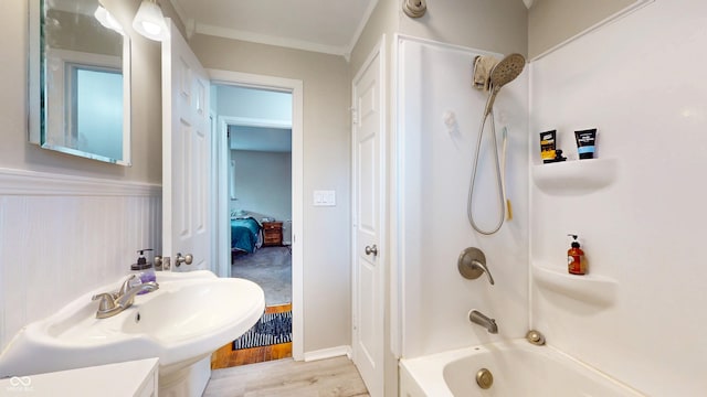 full bath featuring wood finished floors, bathing tub / shower combination, and a sink