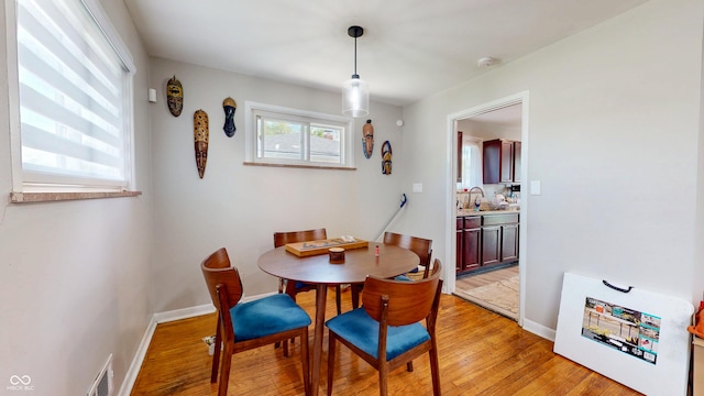 dining space with light wood finished floors and baseboards