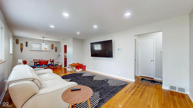 living room featuring hardwood / wood-style flooring, recessed lighting, and baseboards